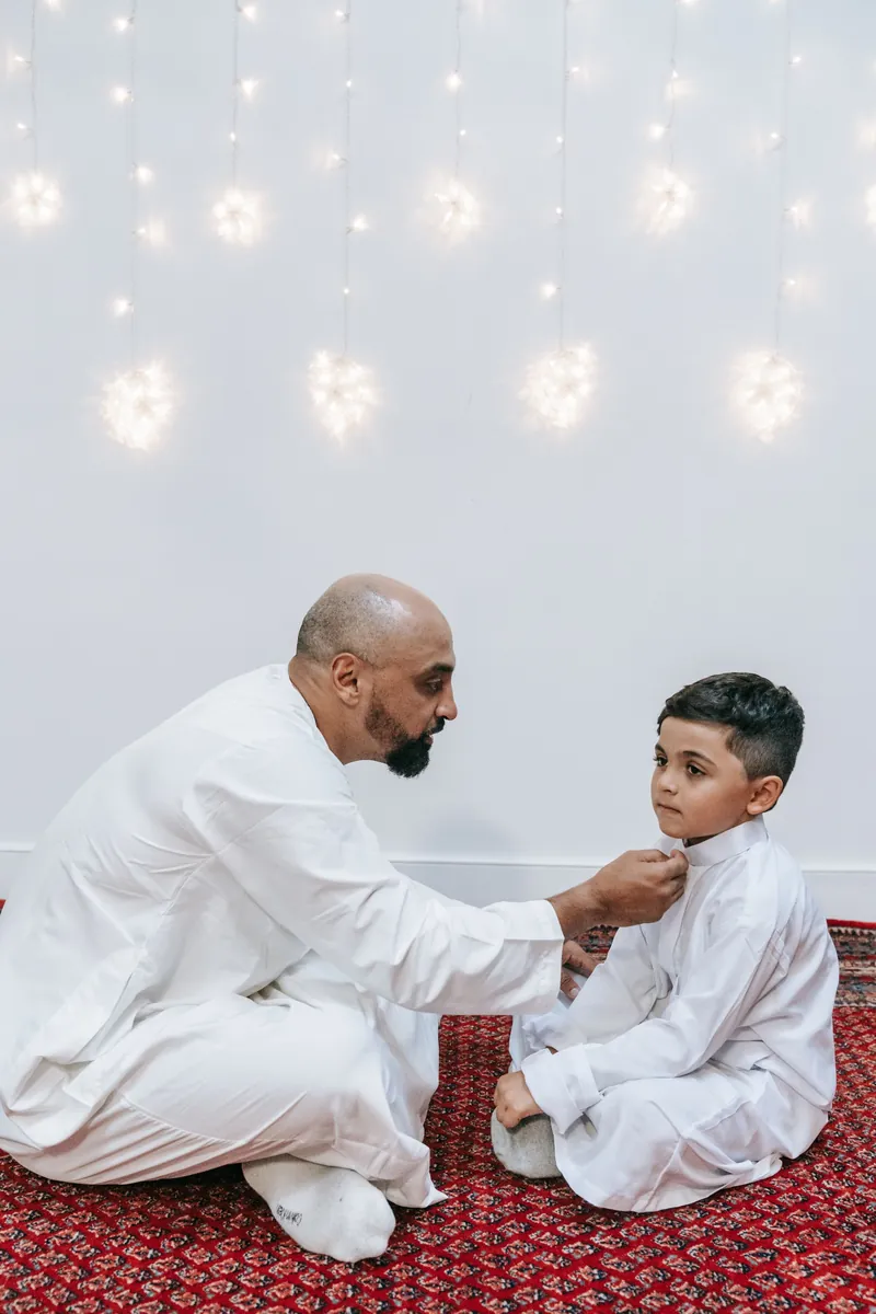 A father helping his young son get ready